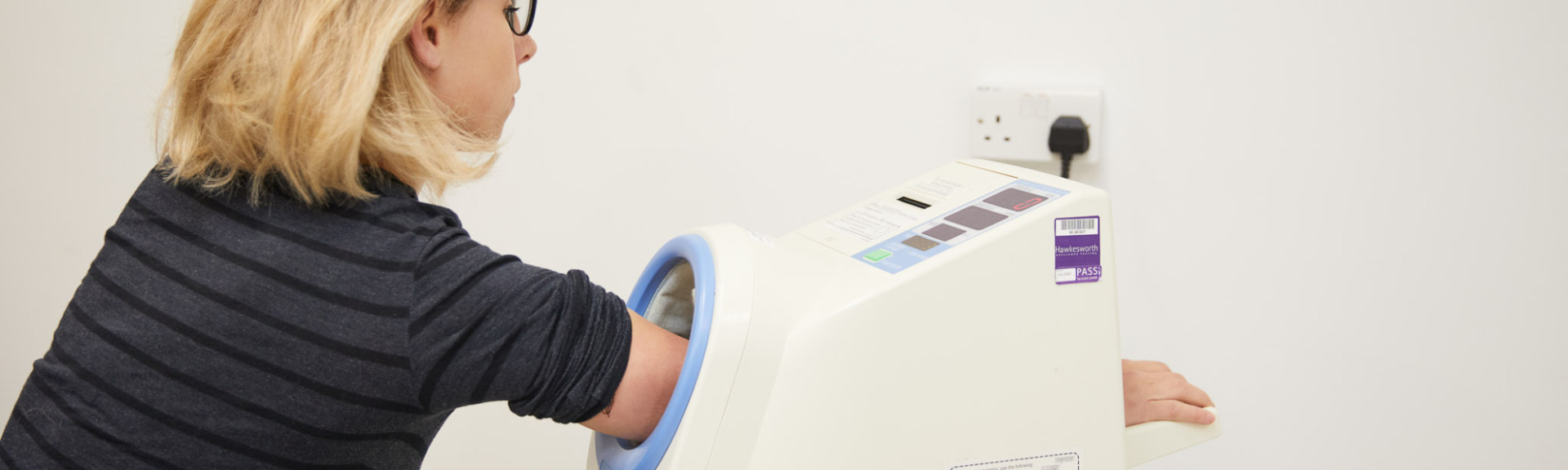 A patient showing a patient using the blood pressure machine in the reception area