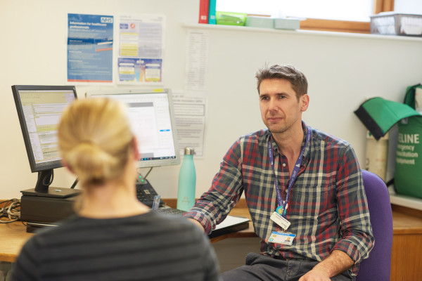 A photo showing Dr Knight speaking to a patient