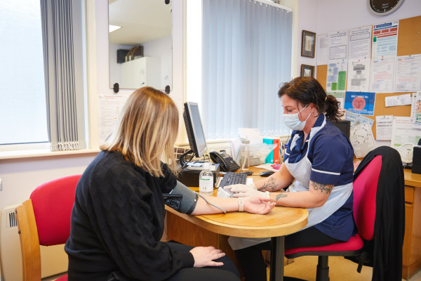 A photo showing a nurse taking a patients blood pressure