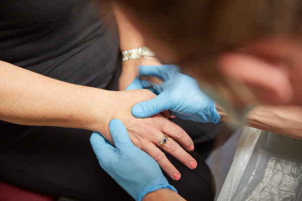 A photo showing a clinician reviewing a patients hand