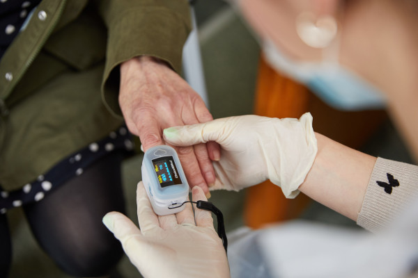 A photo of a patient having their oxygen saturation levels checked